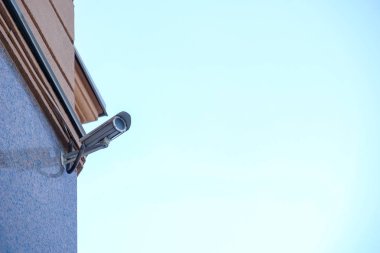 Mavi gökyüzü üzerinde bir bina güvenlik kamerası