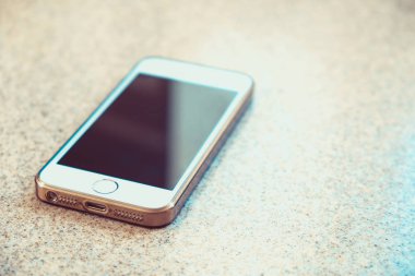 Mutfak masasında güneş ile siyah ekran ile beyaz akıllı telefon kamaşma