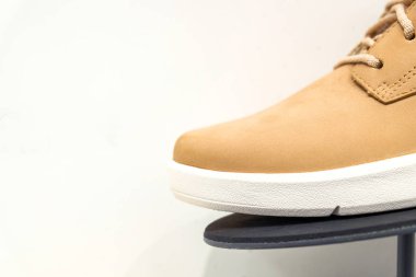 Bir raf kopyalama alanı olan beyaz bir arka plan üzerinde Satılık üzerinde kahverengi spor ayakkabıları. Bir yeni ayakkabı collection.close-up satış konsepti