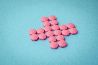 Pembe hap mavi arka plan üzerinde çapraz. Tonda