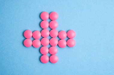 Pembe hap mavi arka plan üzerinde çapraz.