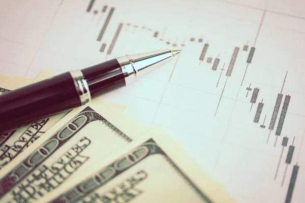 Concept of currency market analysis. Pen on a graph with us dollars. Toned.