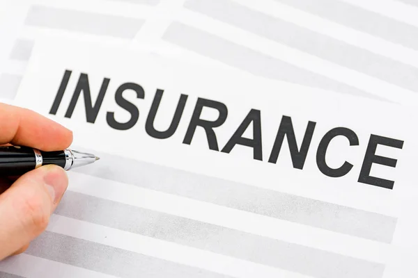 stock image The concept of signing insurance documents. Pen lying with paper printed out the word 