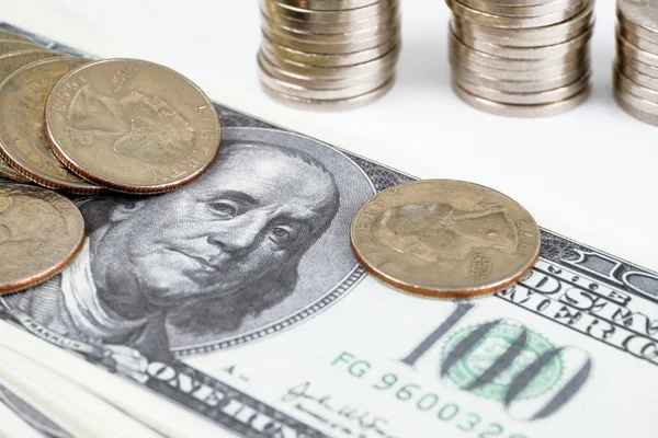 Beyaz bir arka plan üzerinde fatura sikkeler ve yüz doları demir yığınları.