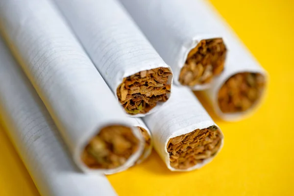 Vários Cigarros Jazem Fundo Amarelo Fechar — Fotografia de Stock