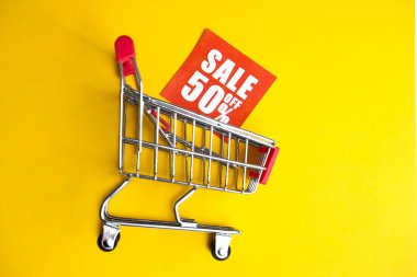 Bir 50% indirim duyuru etiketi ile sarı bir arka planda arabası. Satış kavramı. Yakın çekim.