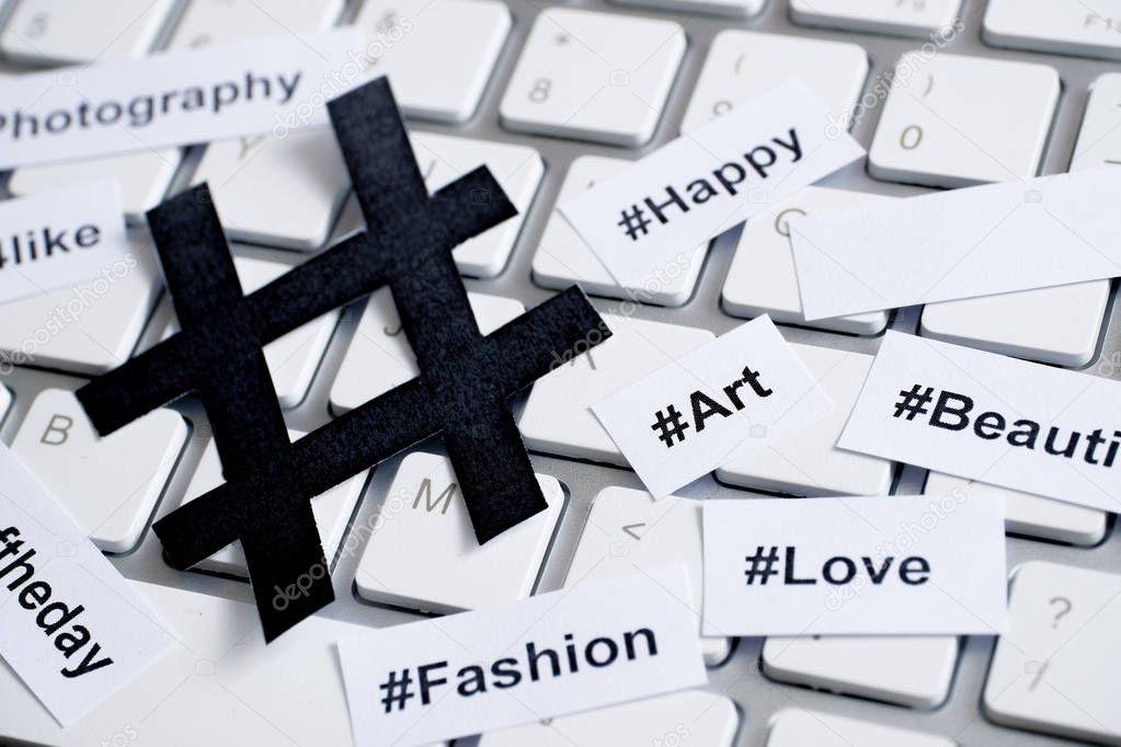 Popular hashtags printed with sign on paper and on the keyboard.