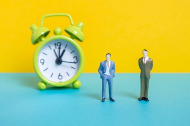 Sarı bir arka planda yeşil Vintage saatin yanında erkekler Dummy.