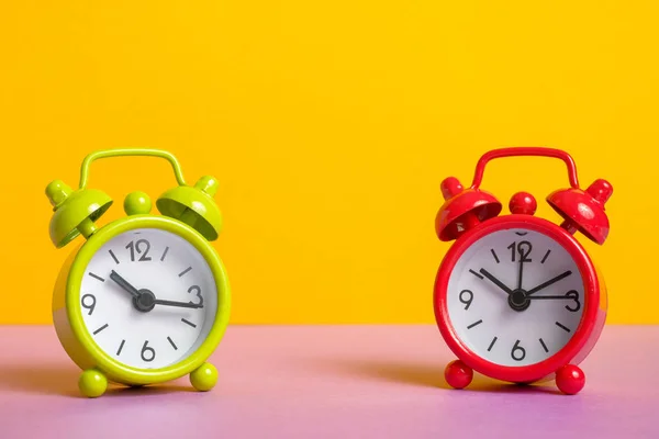 Relógio de alarme vintage verde e vermelho no fundo de cor amarela . — Fotografia de Stock