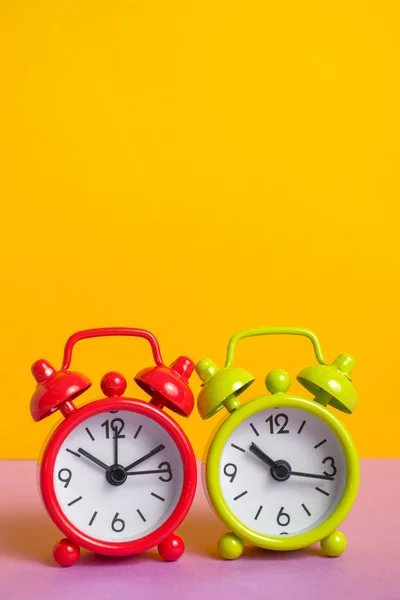 Relógio de alarme vintage verde e vermelho no fundo de cor amarela . — Fotografia de Stock