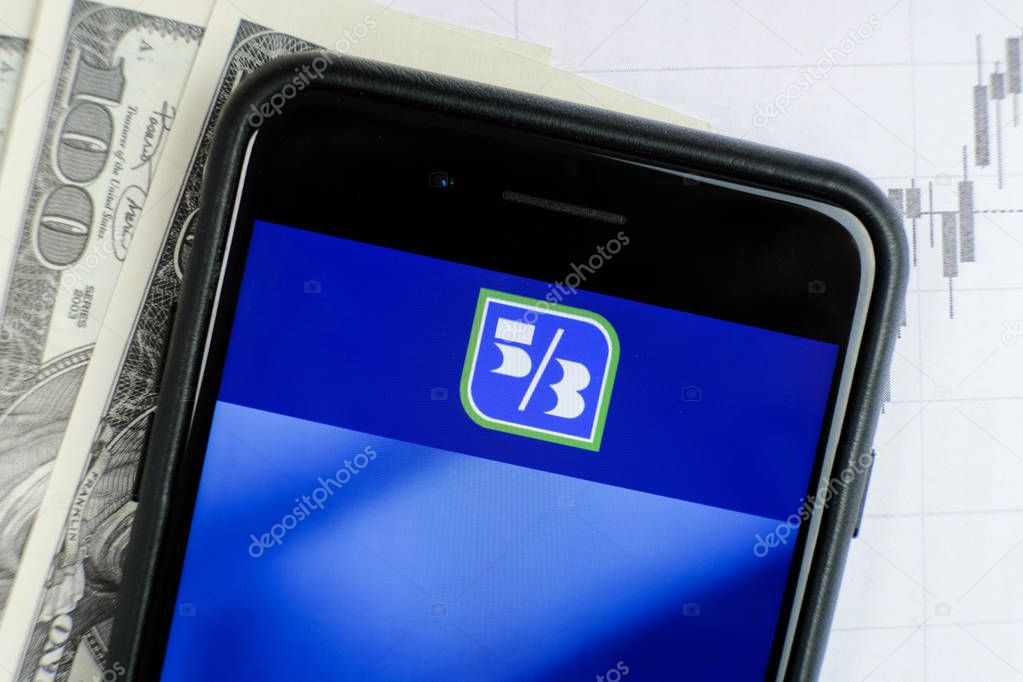 RUSSIA, ST.PETERSBURG, April 4, 2019: site with Logo of the bank Fifth Third Bancorp in the smartphone lying on paper with charts and one hundred dollar bills.