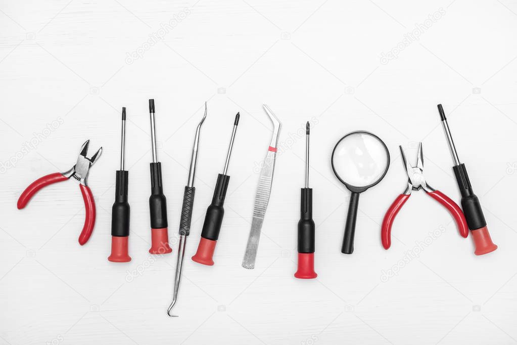 Electronics repair tools are lined in a row in the center white background.