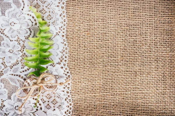 Wedding gold rings on rustic background of lace and burlap. Concept for postcard.