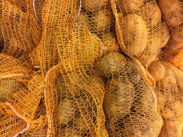 Batatas frescas no pacote sob a forma de uma grelha amarela . — Fotografia de Stock