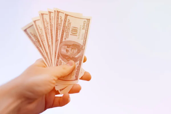 Hand streckt uns Hundert-Dollar-Scheine isoliert auf weißem Hintergrund entgegen. Zahlung, Gebühr, Kredit. — Stockfoto