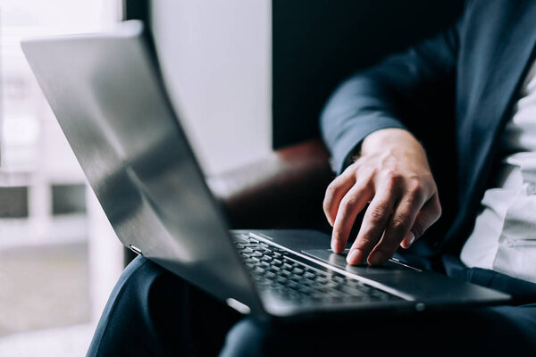 Businessman leads hand on a laptop keyboard. Concept surfing the internet.