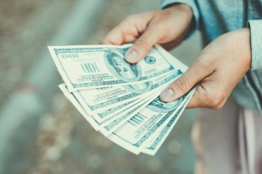 Sokakta yüz dolarlık banknotlar sayıyor..