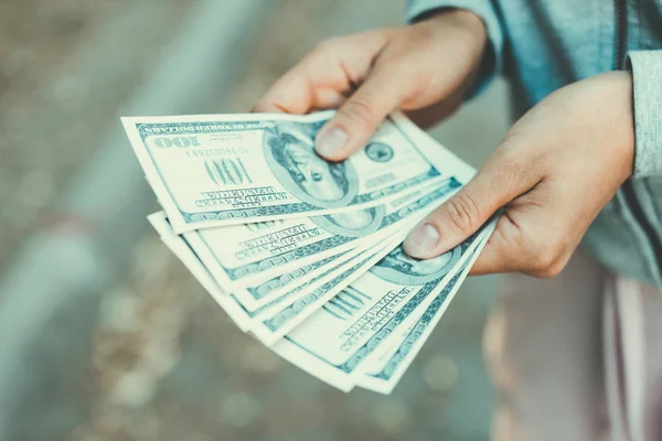 Aproape de mâini numărând bancnote de 100 de dolari pe stradă . — Fotografie, imagine de stoc