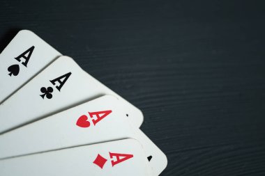Siyah ahşap arka plan üzerinde yalan dört as.