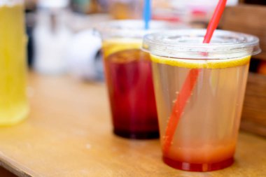 Taze meyvelerden yapılan doğal meyve suyu. Sokakta plastik bir bardak barda Içki.