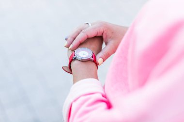 Kadın elinin yakın çekim arka plan kaldırımda bilek kol saatine dokunur.