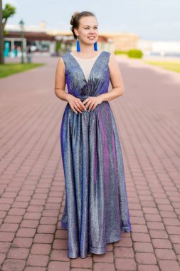 Ametist zemin uzunluğunda ışıltılı elbise kaldırımda gülümseyen rüya gibi genç Kafkas kadın.