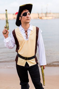 Korsan kostümlü adam en üst oyuncak silahına yükseltildi.