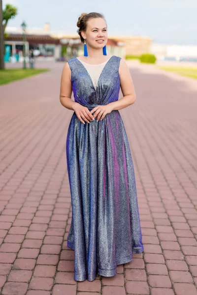 Ametist zemin uzunluğunda ışıltılı elbise kaldırımda gülümseyen rüya gibi genç Kafkas kadın.