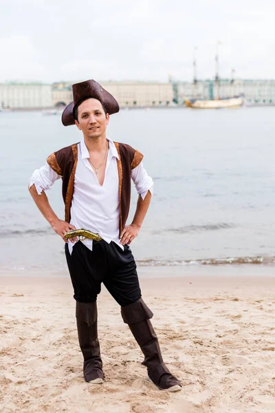 L'uomo in costume da pirata mise le mani sui fianchi sulla spiaggia . — Foto Stock