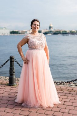 Pembe elbiseli esmer beyaz model rıhtımda kalçaellerini koydu.