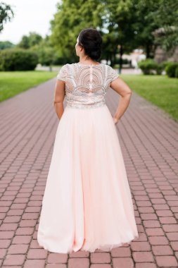 Uzun pastel pembe elbise esmer kafkas modeli parkta onu geri döndü.