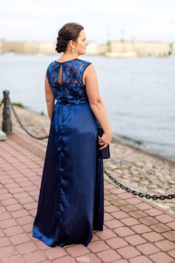 Uzun mavi ipek elbiseli esmer beyaz model rıhtıma sırtını döndü.