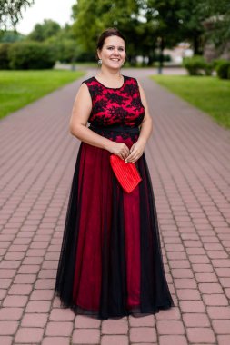 Parkta nakış lı zemin uzunluğunda siyah ve kırmızı elbiseli esmer kafkas modeli.