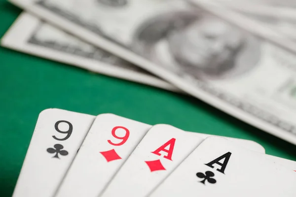 Две пары тузов и девяток во время покера с долларами на зеленом столе . — стоковое фото