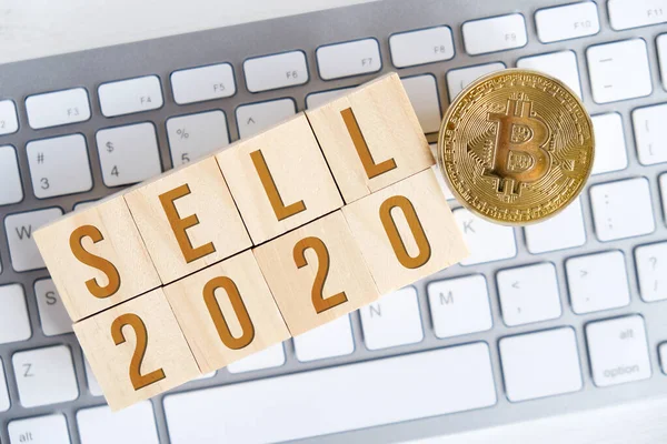 Bitcoin mit Zahlen 2020 auf Holzwürfeln auf einer weißen Tastatur mit Holzhintergrund. Erfolg beim Verkauf von Kryptowährungen im neuen Jahr. flache Lage. — Stockfoto