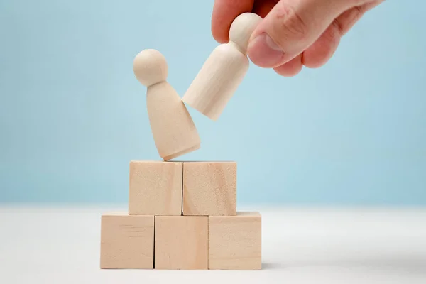 Hand zet houten figuur op het podium verschuiven van de figuur staande t — Stockfoto