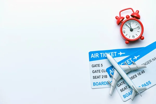 Airplane tickets with red clock on a white background
