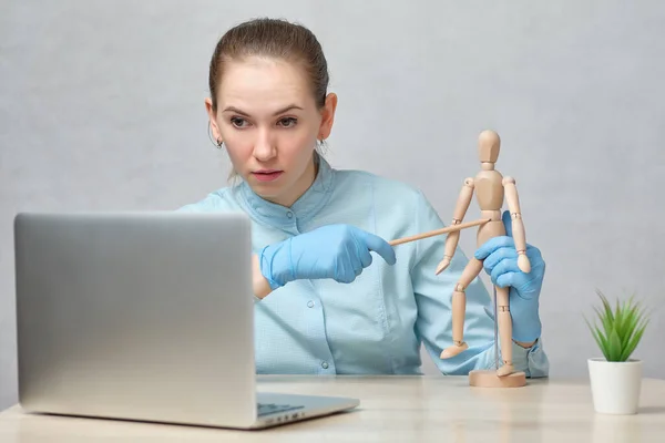 Doctor teacher tells an online lecture on the stomach showing on a mannequin