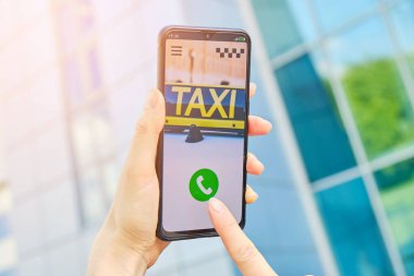 Başvuru formu ile taksi çağırma kavramı. Bir el, sokakta akıllı telefonu tutar.