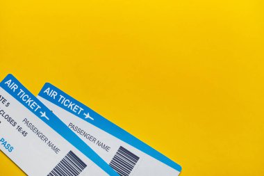Sarı arka plan fotokopi alanı ve üst görünüm üzerinde uçak biletleri