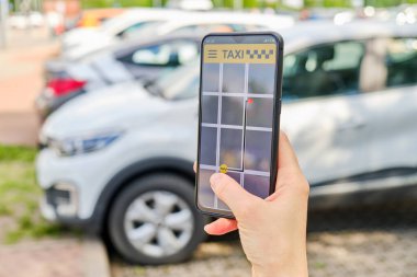Bir el akıllı telefonu tutar ve taksiye biner..