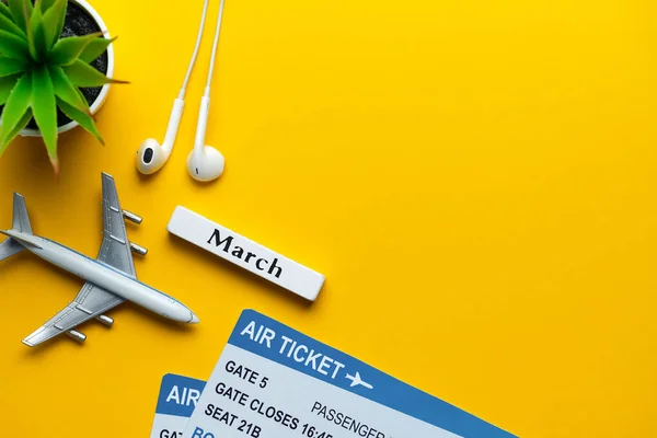 三月假期概念 玩具飞机与黄色背景的票 复制空间 — 图库照片