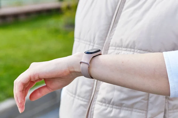 Girl looks at smart watch on the street