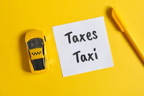 Taxi Skatt Koncept Som Inskription Ett Klistermärke Bredvid Leksaksbil Gul — Stockfoto