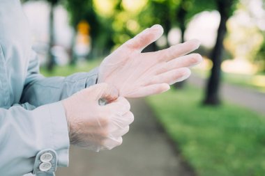 Genç kız şehirde tıbbi koruyucu eldiven takıyor..