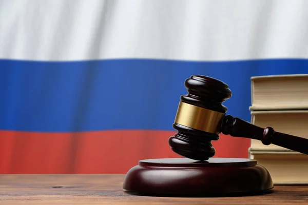 Justice and court concept in Russian Federation. Judge hammer on a flag background.