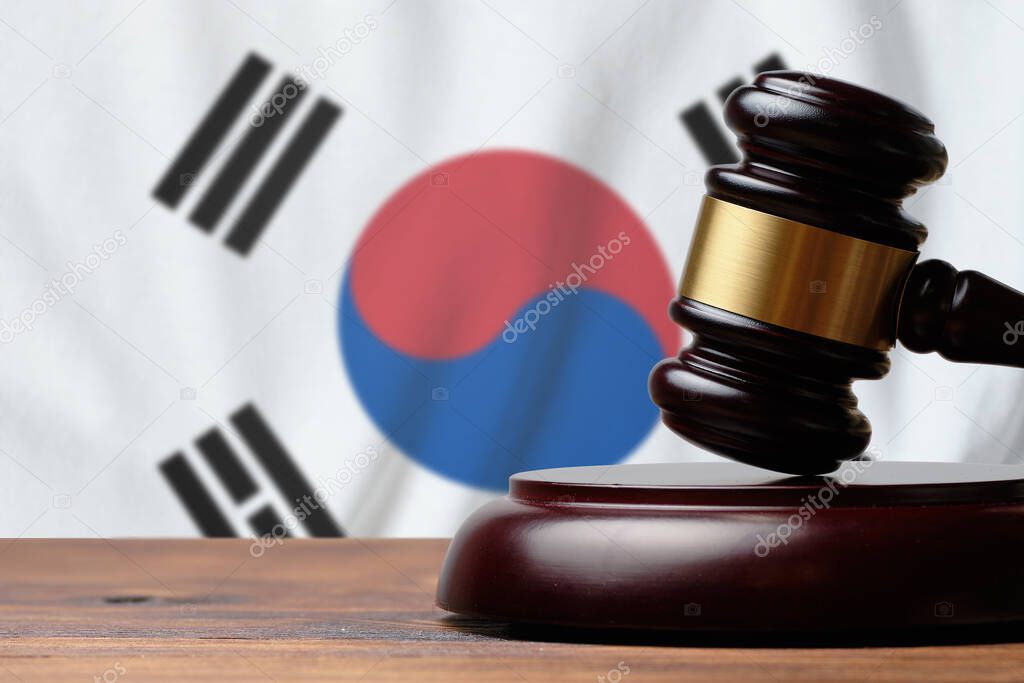 Justice and court concept in South Korea. Judge hammer on a flag background.