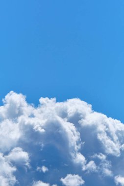 Yazın mavi gökyüzüne karşı kalın bulutlar. Dikey.