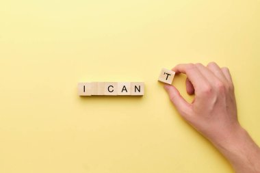 Motivasyonal ifade konsepti, yapabilirim. Elin ahşap bir bloğu tutuyor.