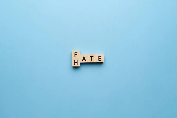 The concept of hate and fate. Letters on a blue background